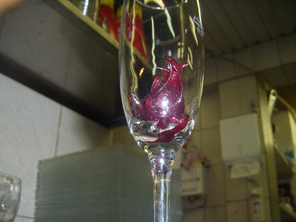 Glas Champagner mit Hibiskusblüte dazu einen Gruß aus der Küche